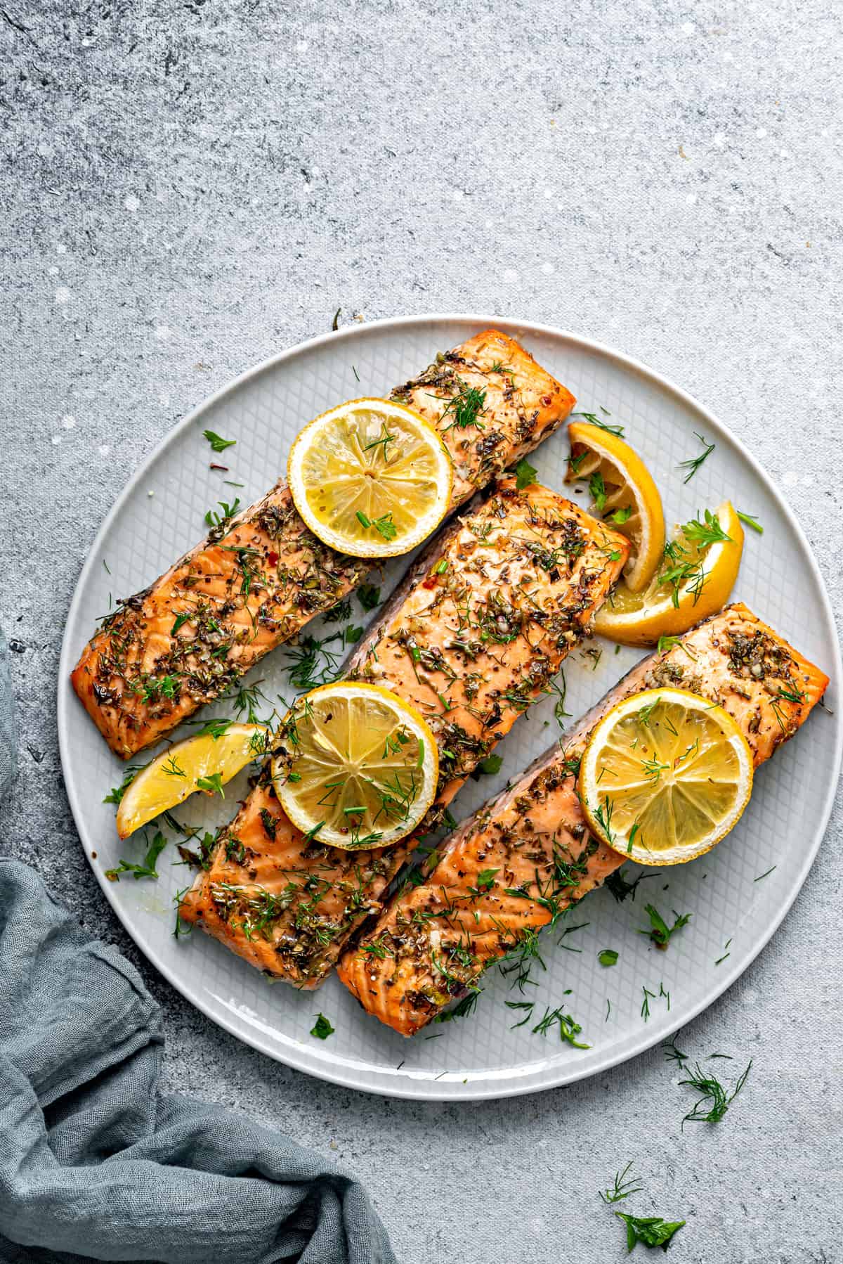 Top down view baked salmon recipe final shot: Three fillets on a plate.