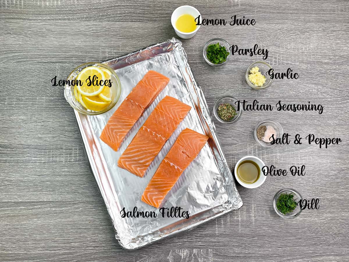Recipe ingredients: three fillets on a foil lined baking sheet surrounded by individual spices and aromatics in small glass dishes.