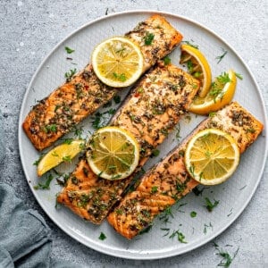 Top down view baked salmon recipe final shot: Three fillets on a plate.