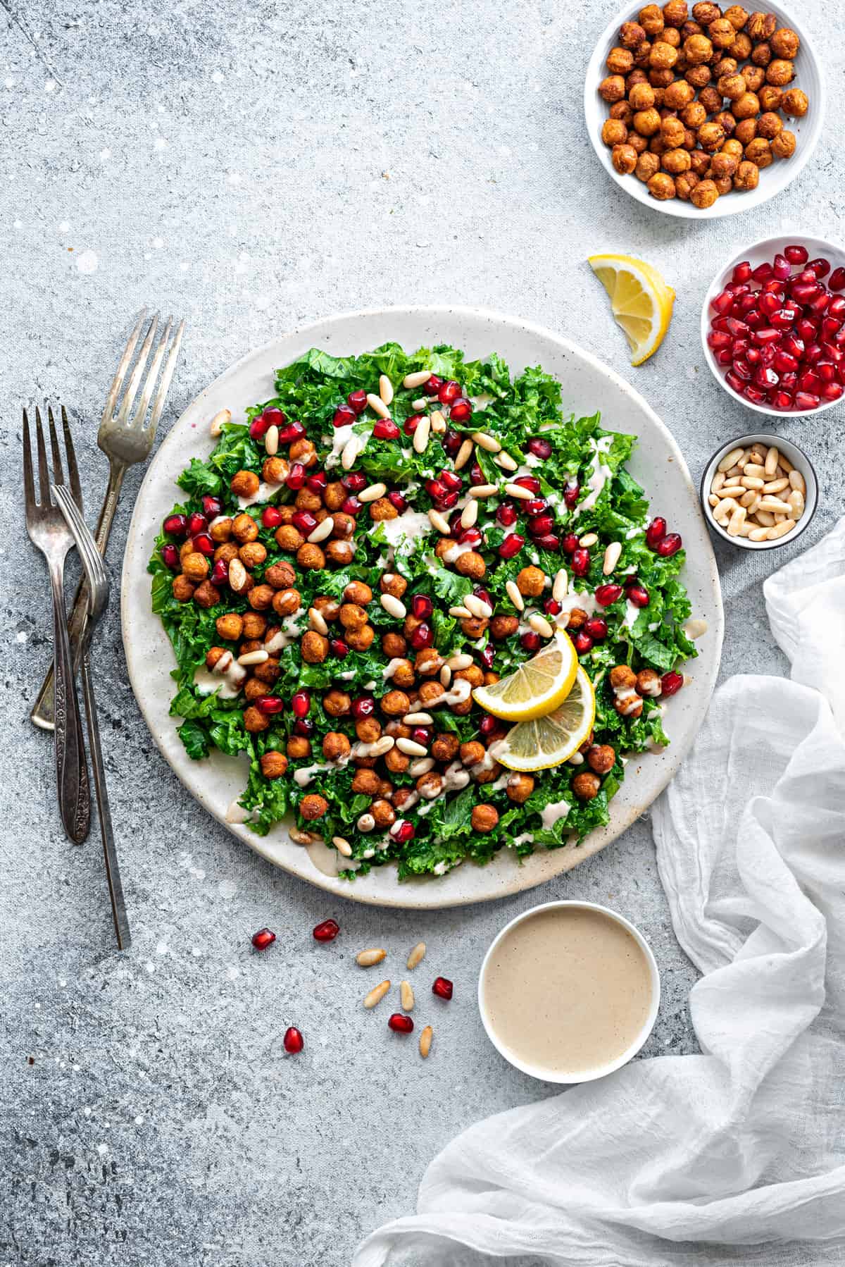 Overhead shot from vegan gluten free kale salad on a plate with ramekin of tahini sauce on the side.