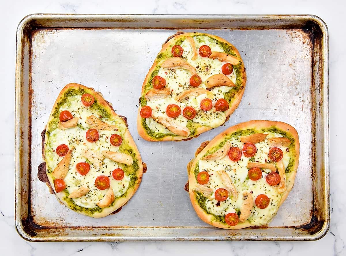 3 baked pizzas on a baking sheet.