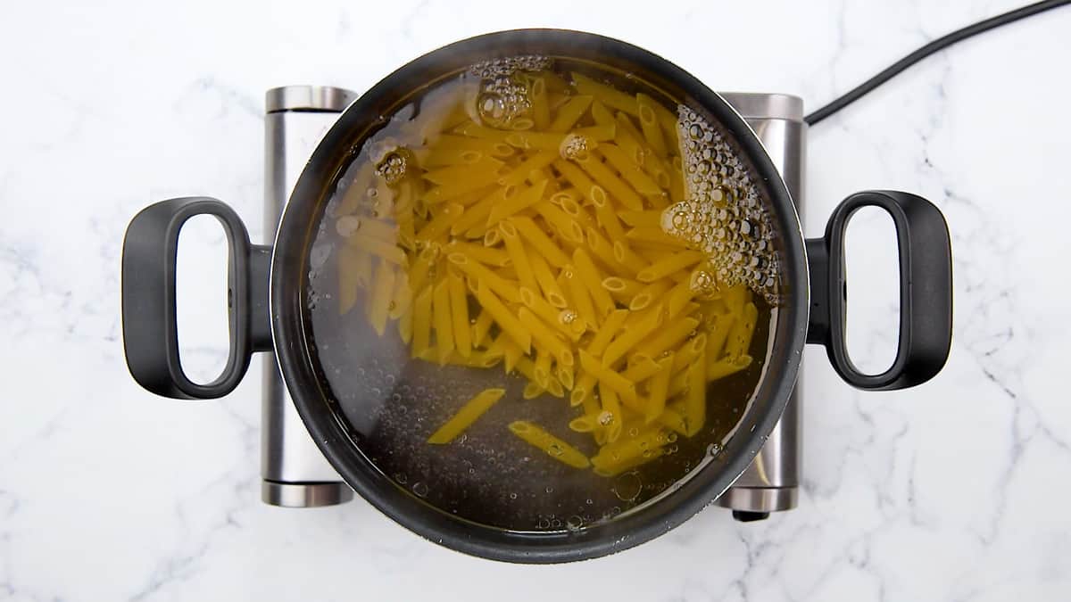 Boiling noodles in a large pot.