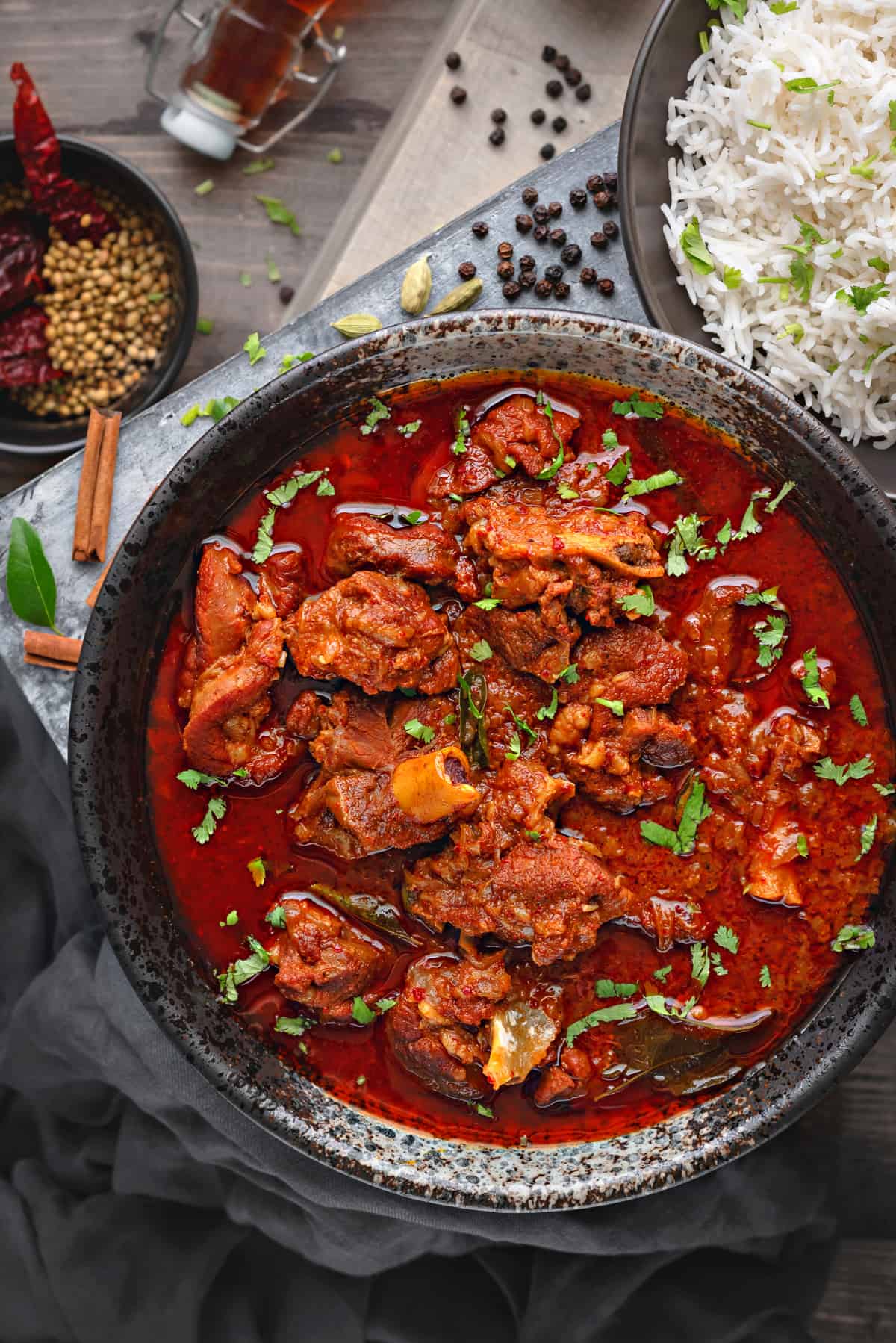 Close-up view of lamb vindaloo curry served in black bowl.