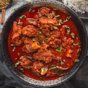 Lamb Vindaloo curry served in black bowl.