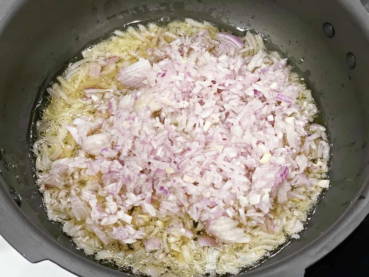 Chopped onion added to the hot oil in traditional pressure cooker.
