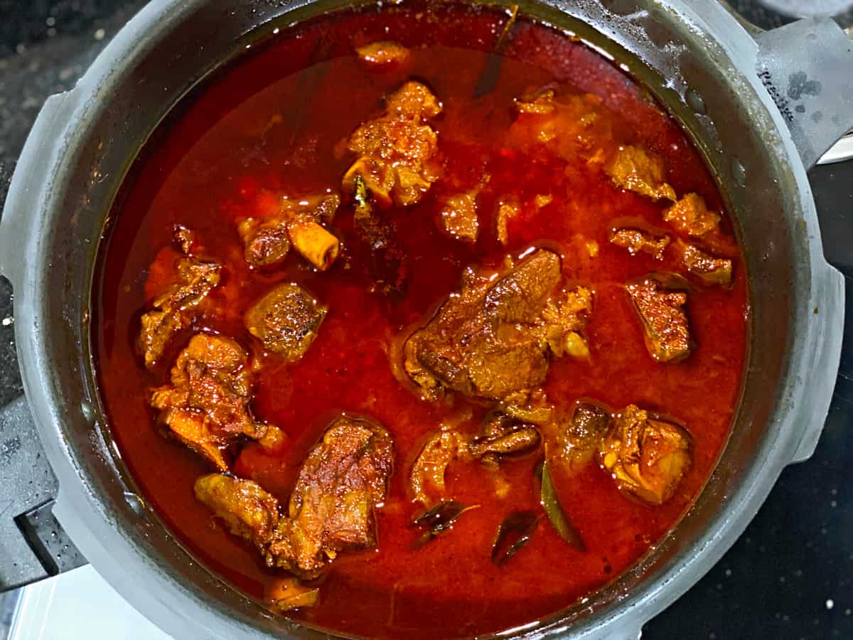 Cooked lamb vindaloo in traditional pressure cooker ready to serve.