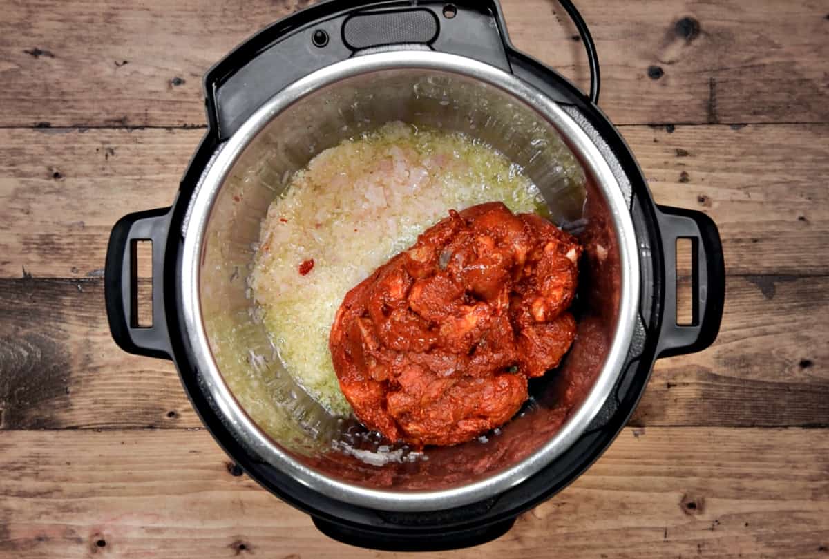 Marinated lamb pieces added to the instant pot.