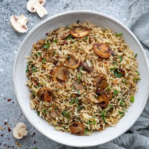 Mushroom rice served in white earthen bowl.