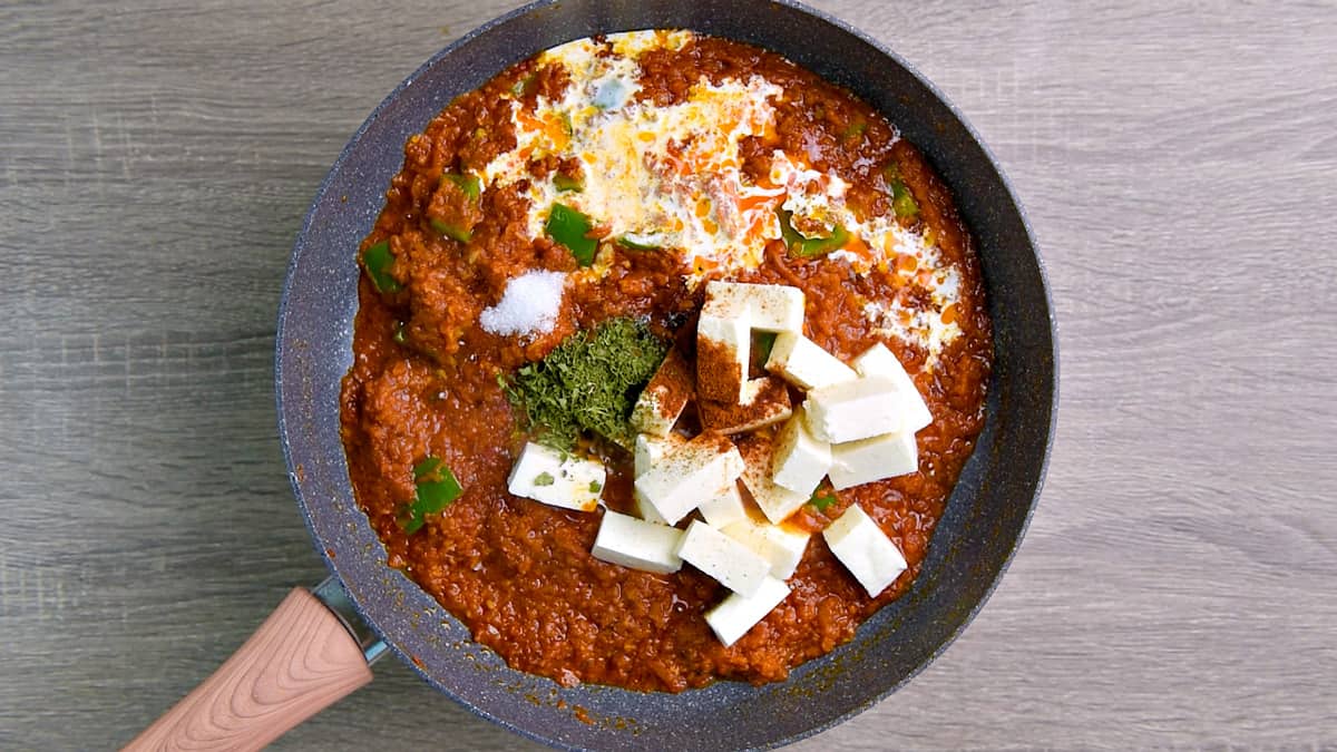 Cubed paneer, garam masala powder, cream, dried fenugreek and sugar added to the tawa masala.