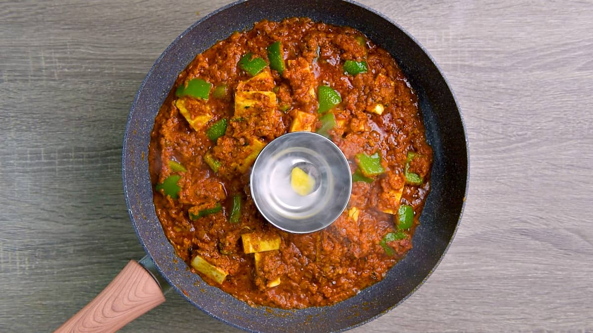 Ghee topped over live charcoal in small steel bowl placed on cooked paneer masala to give smoky flavor.