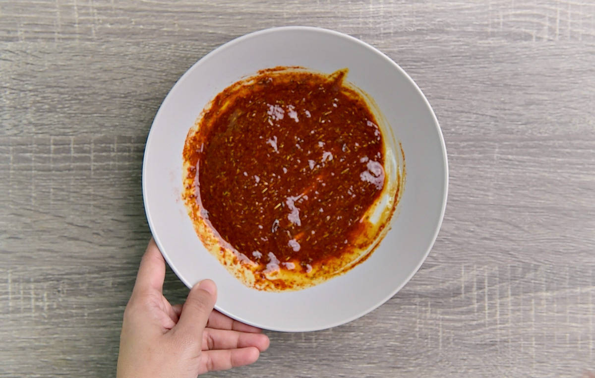 Red spiced marinade mixed together in a white bowl.