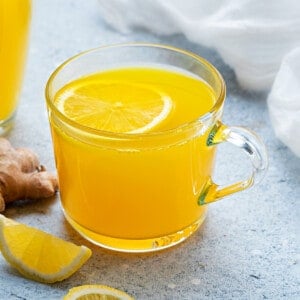 Close up shot of ginger turmeric tea in a glass mug.