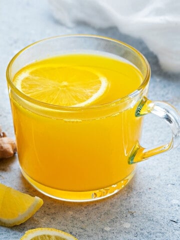 Close up shot of ginger turmeric tea in a glass mug.