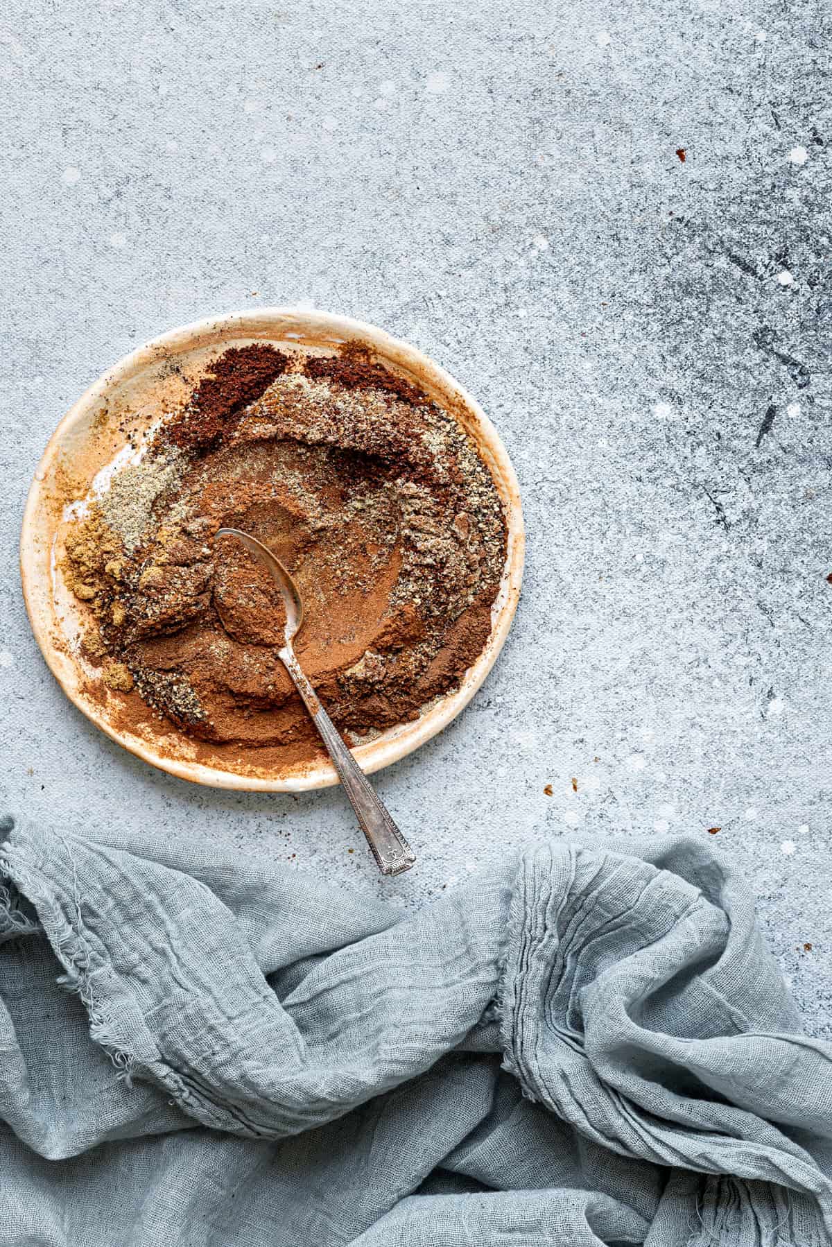 A bowl of the spices blended together with a spoon.