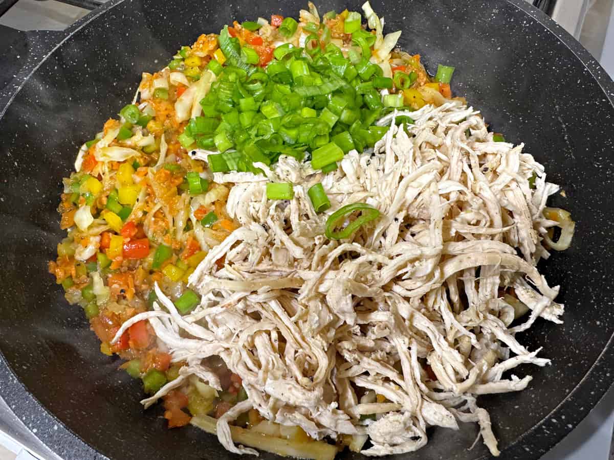 Add boiled and shredded chicken, scallion greens to the skillet.