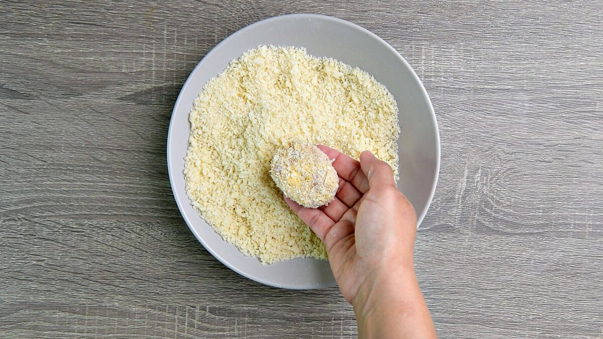 Coating the nugget in panko bread crumbs.