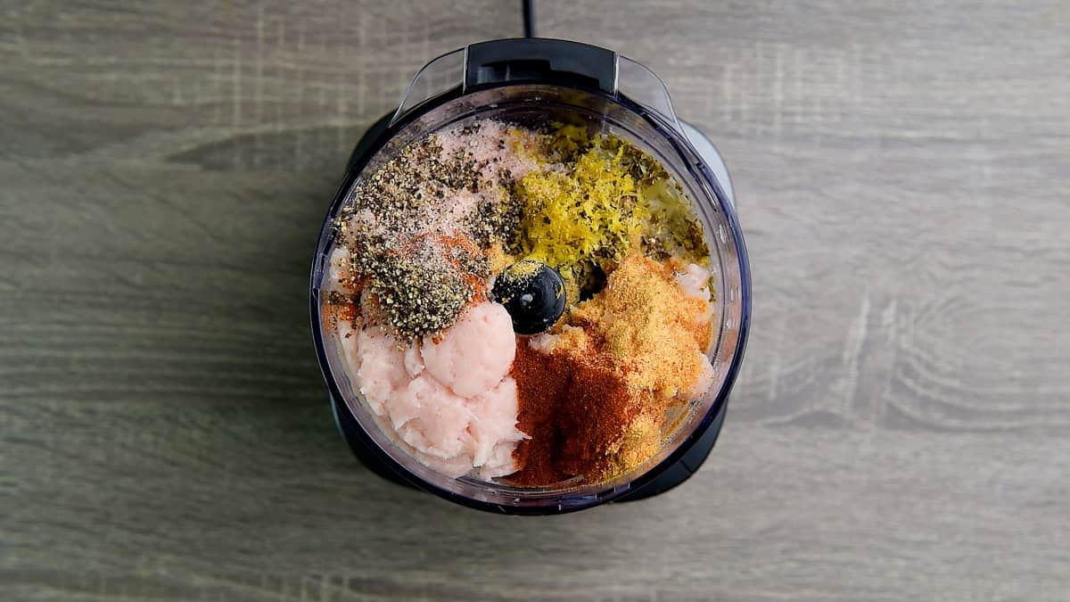 Seasonings added to the chopper with boneless chicken.