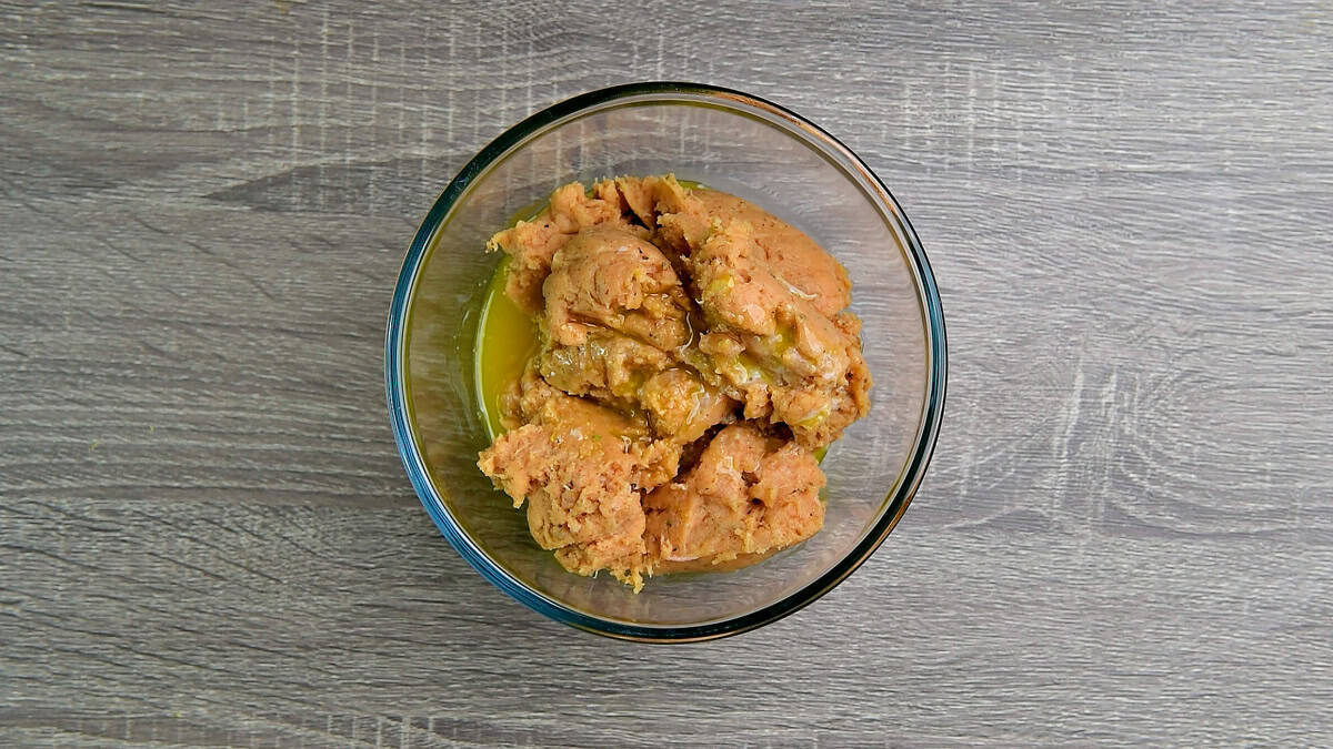 Chicken mixture with melted butter in a bowl.