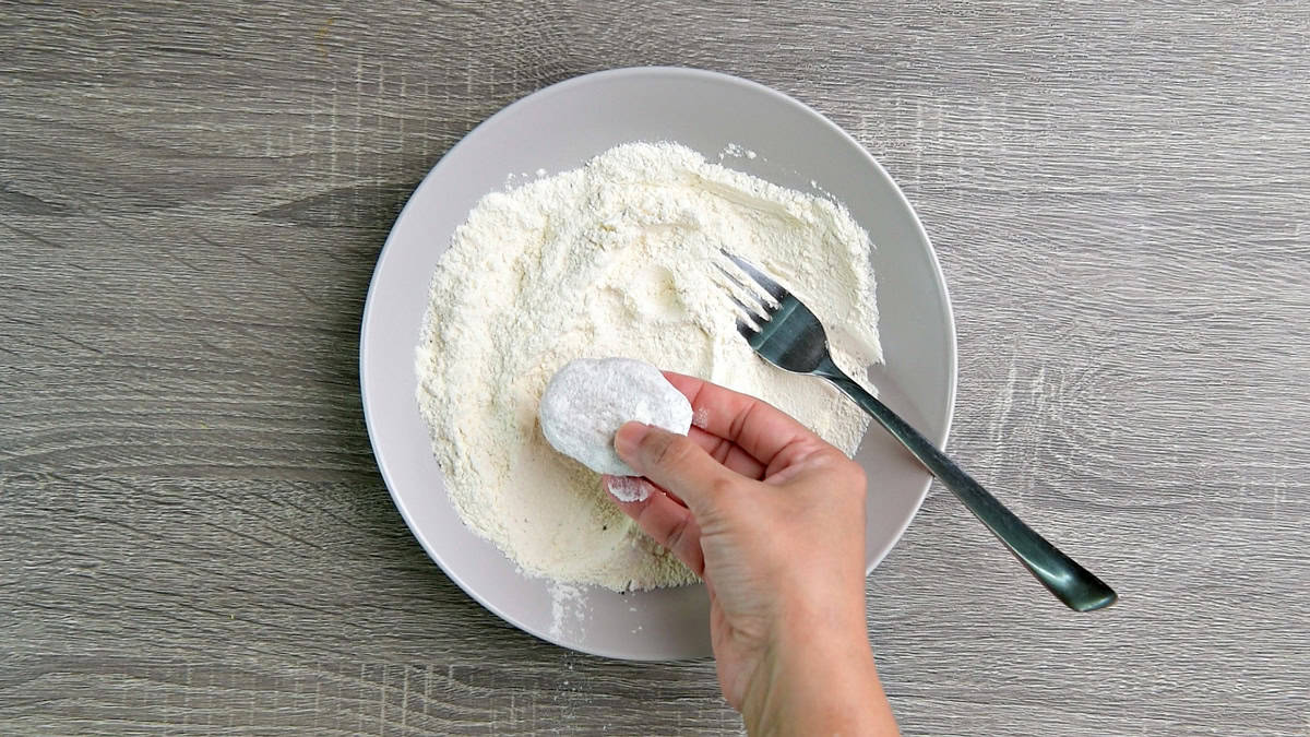 Coating chicken nugget into the seasoned flour mixture.