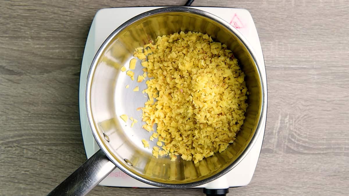 Chopped ginger with peel in a sauce pan.