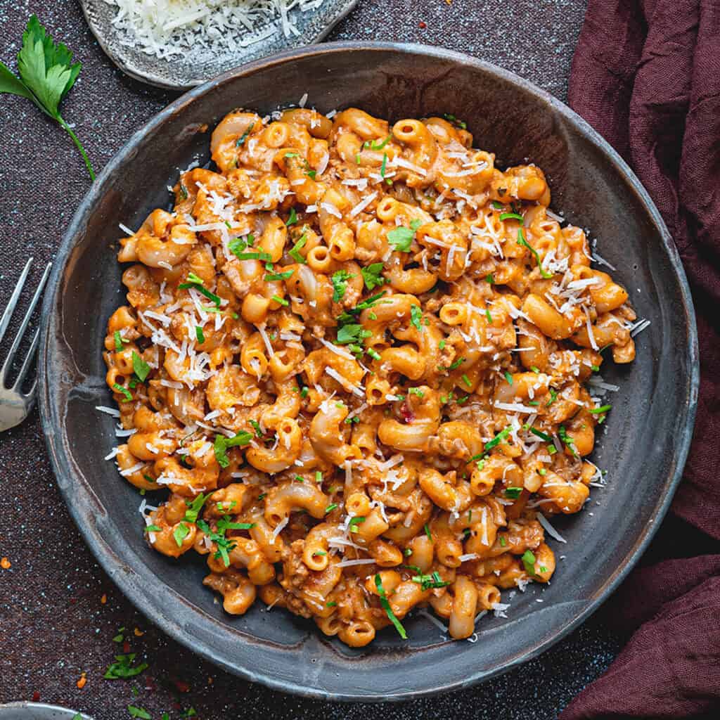 Top down view of a gray bowlful of creamy ground beef pasta.