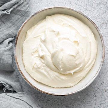 A bowl of homemade sour cream on a table, whipped and ready to be used.