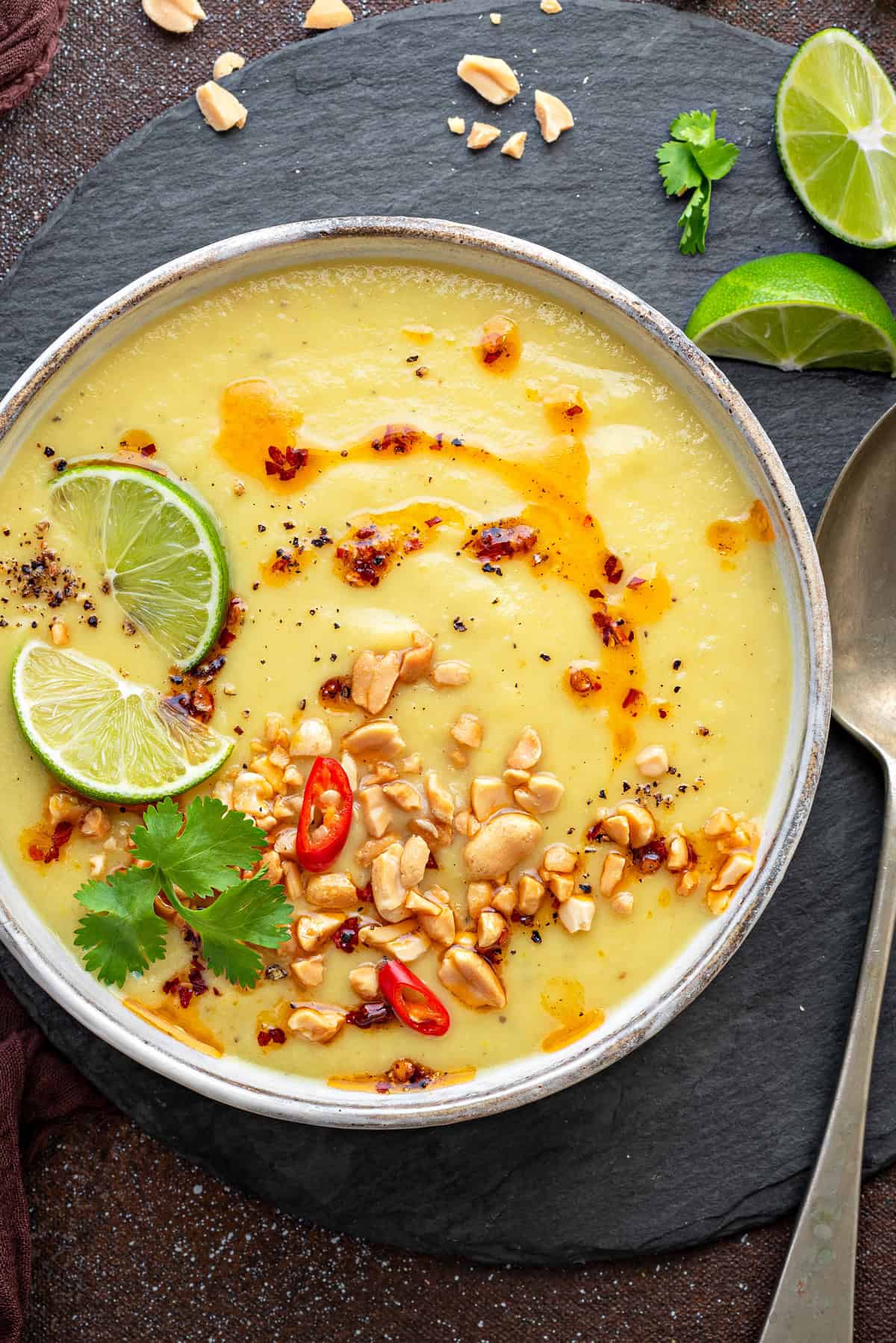 Top-down view of Parsnip Soup with apple that has chili oil, nuts, chili lime, and cilantro.