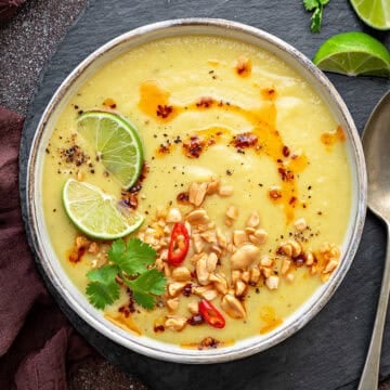 Top-down view of Parsnip Soup with apple that has chili oil, nuts, chili lime, and cilantro.
