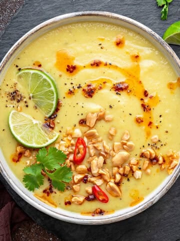 Top-down view of Parsnip Soup with apple that has chili oil, nuts, chili lime, and cilantro.