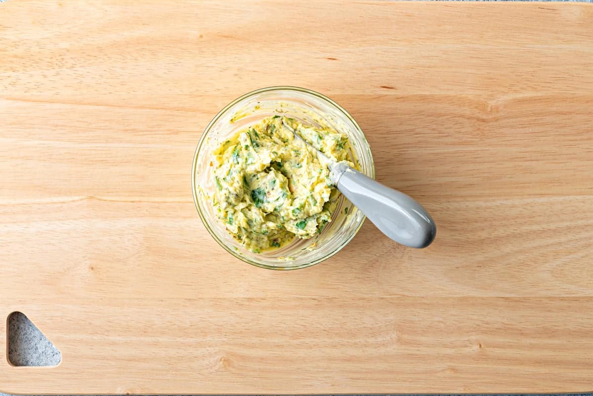 Top-down view of ingredients in bowl that have been mixed together to make garlic butter.