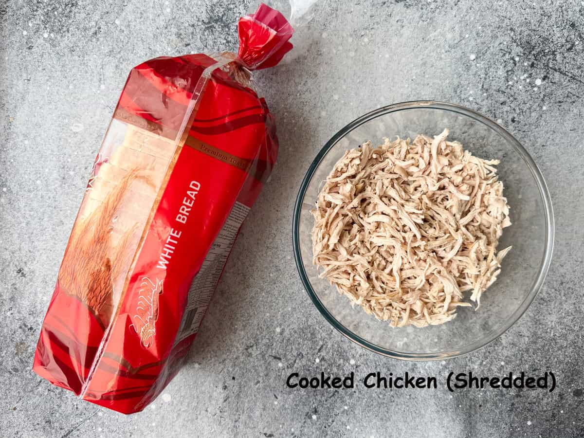 ingredients: A bowl of shredded chicken and a loaf of white bread for making sandwiches.