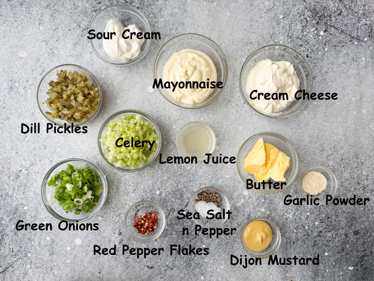 Other ingredients in individual glass bowls that includes sour cream, mayonnaise, cream cheese, dill pickles, celery, lemon juice, butter, garlic powder, green onions, red pepper flakes, salt, pepper, and Dijon mustard.