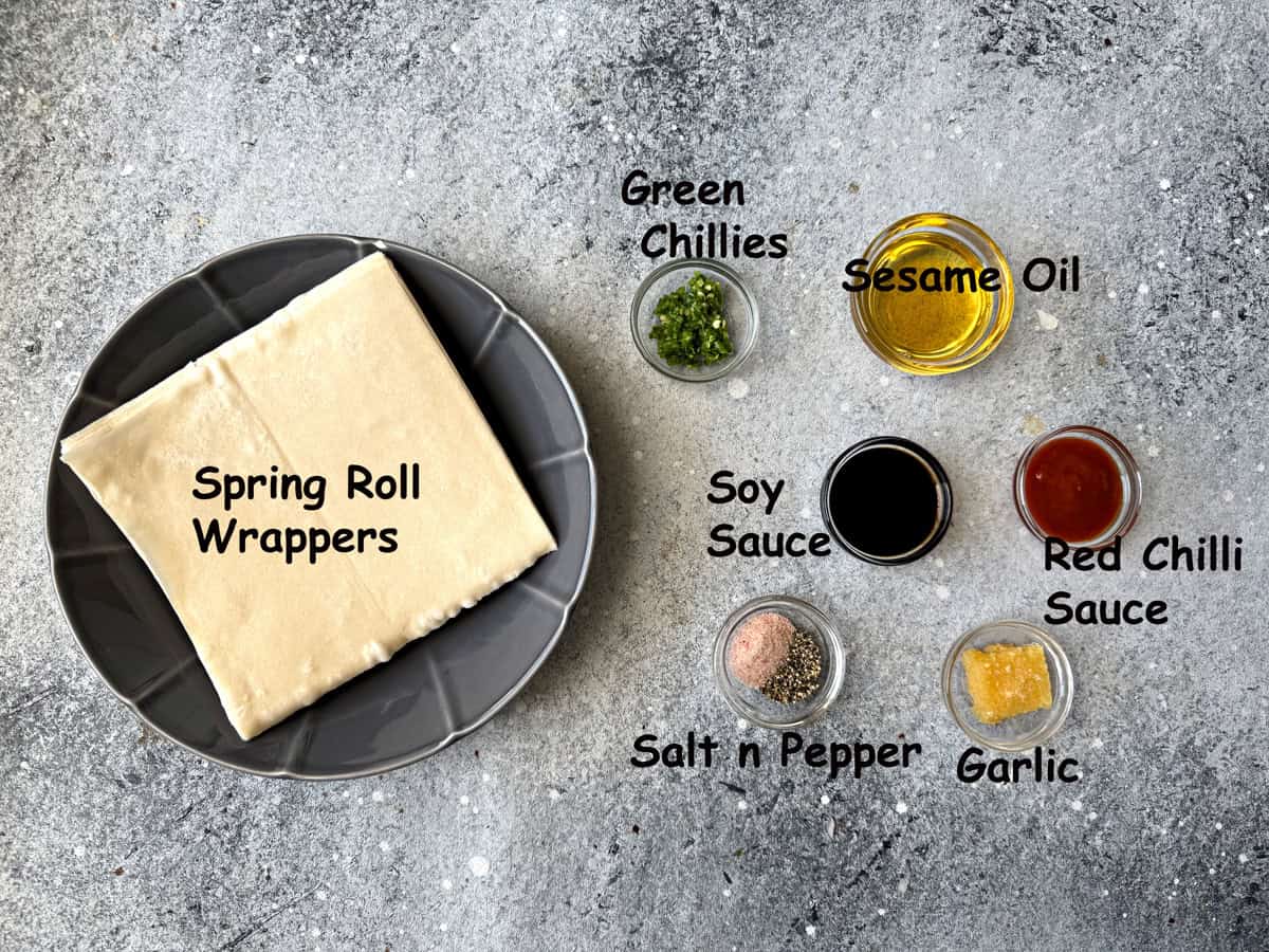 Spring roll wrappers and seasoning ingredients that include garlic, green chilies, sesame oil, soy sauce, red chili sauce, salt and pepper.