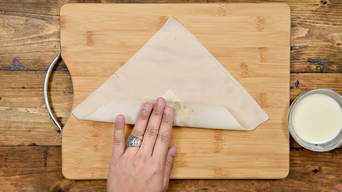 Wrapper folded tightly over filling to begin rolling.