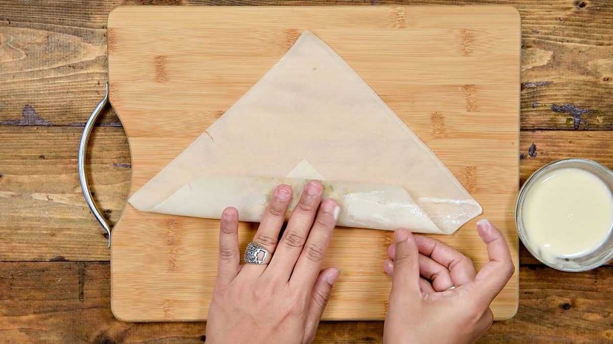 Wrapper folded tightly over with filling and binder applied to both side corners.