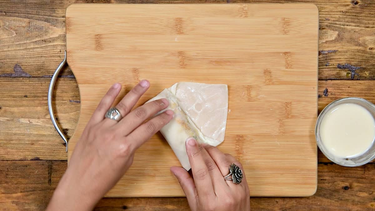 Top-down view of the final roll of the spring roll with paste.