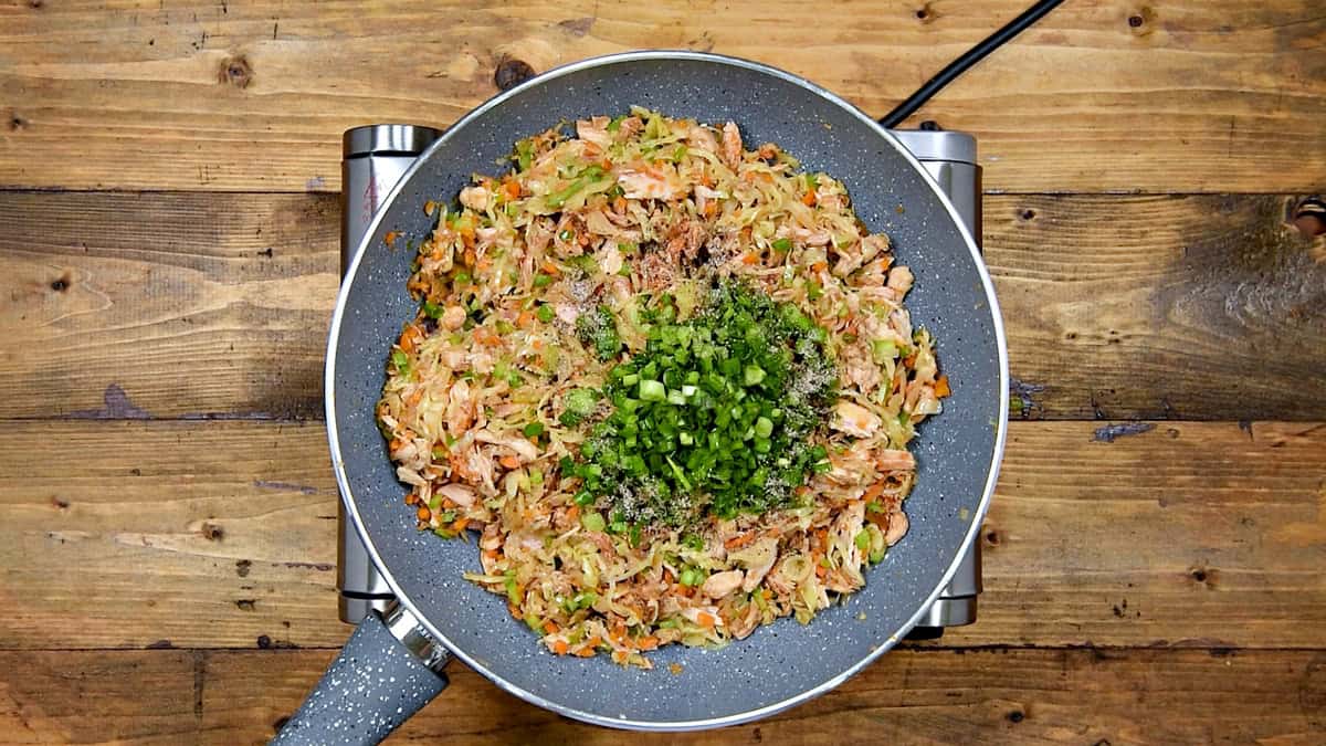 Fresh scallion greens and black pepper mixed into filling the wok.
