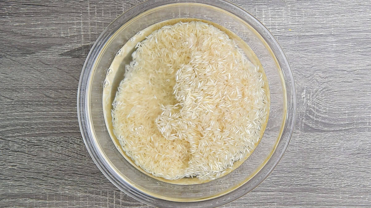 Water added to the large glass bowl with basmati rice to rinse it well.