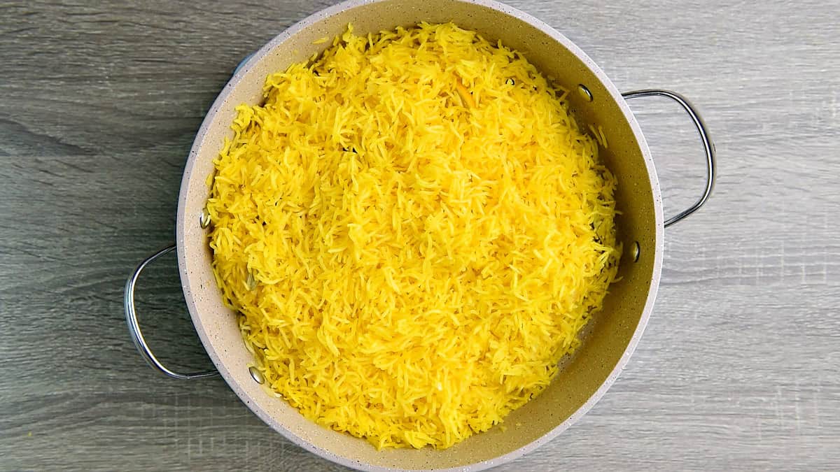 A top-down view of cooked Middle Eastern saffron basmati rice resting in a pan and ready to be served.