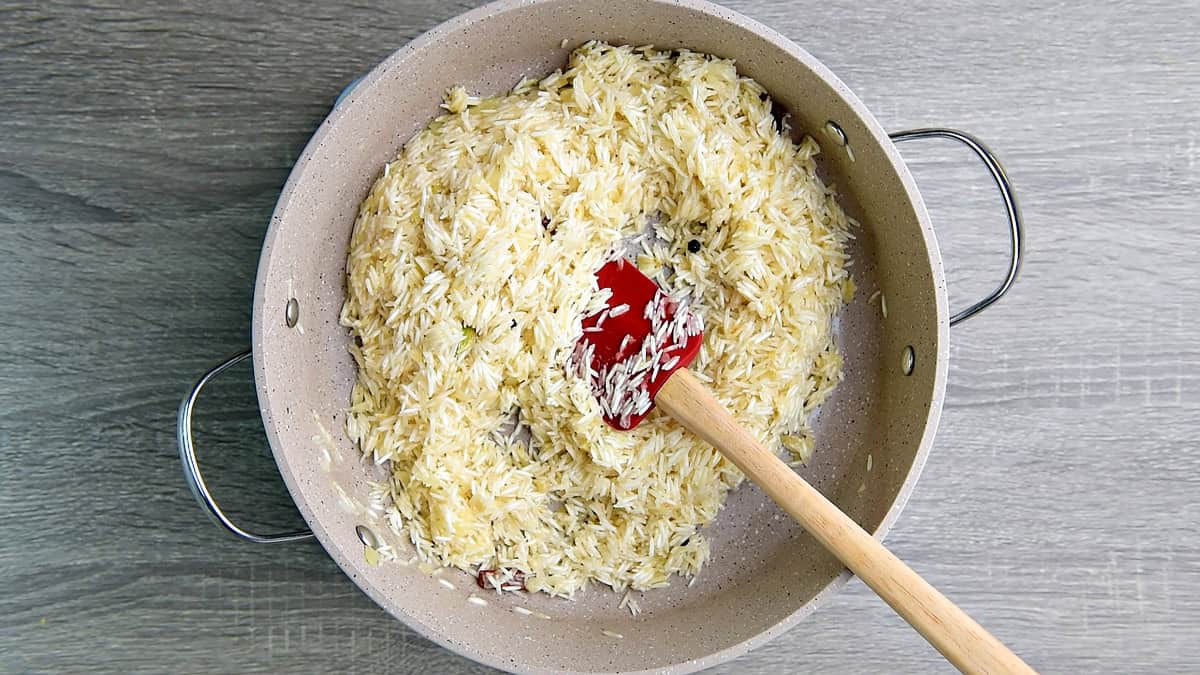 Washed and rinsed rice added to the skillet for toasting with spices and onion.