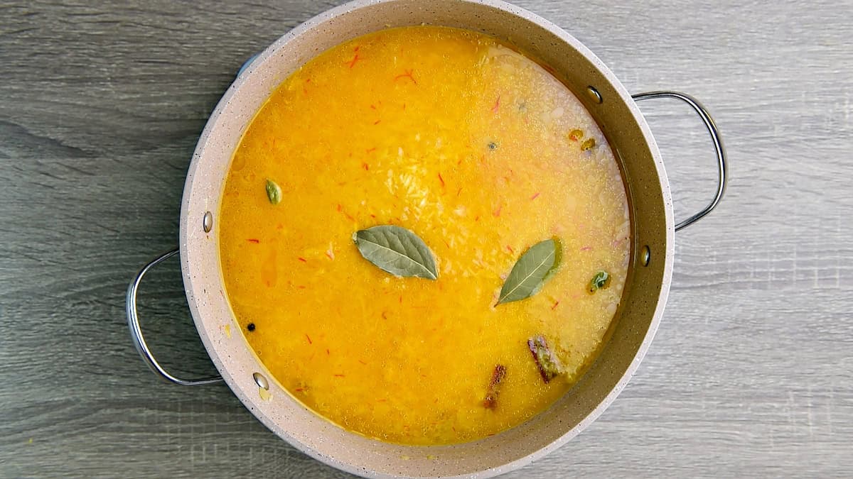 Bay leaves added to the skillet and water brought to a rolling boil on high heat so that water is absorbed up to 60%.