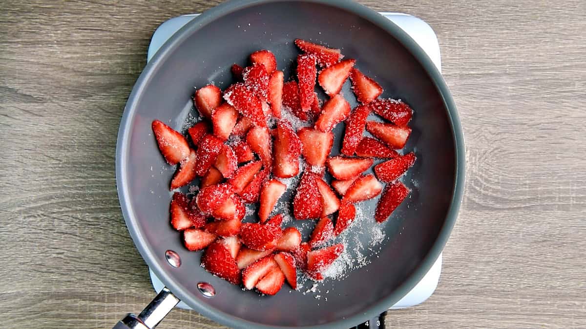 Strawberries mixed and evenly coated with the sugar.