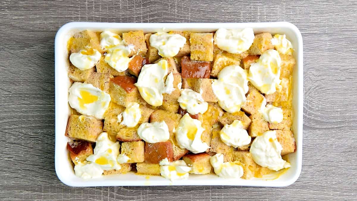 Melted butter drizzled over the brioche cubes dolloped with cream cheese mixture.