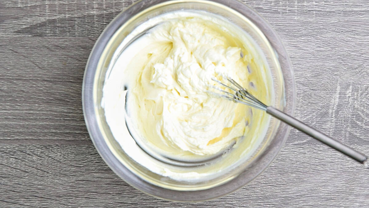 Room temperature cream cheese in a bowl that has been thoroughly whisked for a smooth texture.