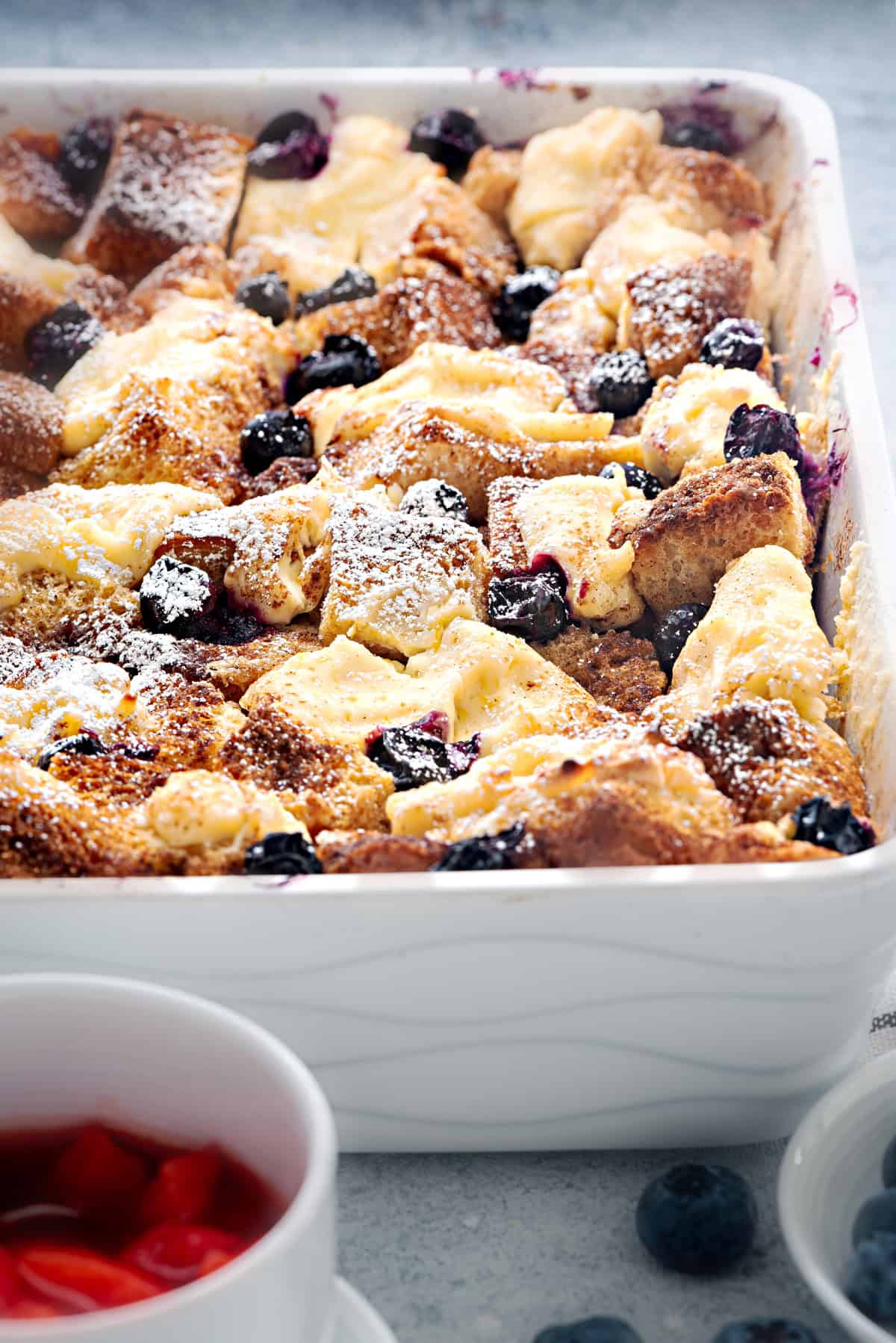 A close up of french toast bake that has been dusted with confectioner's sugar.