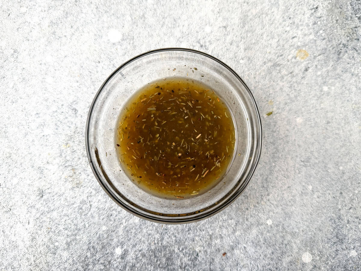 EVOO, balsamic vinegar, lemon juice, honey, and spices in a bowl and more whisked together for a vinaigrette.