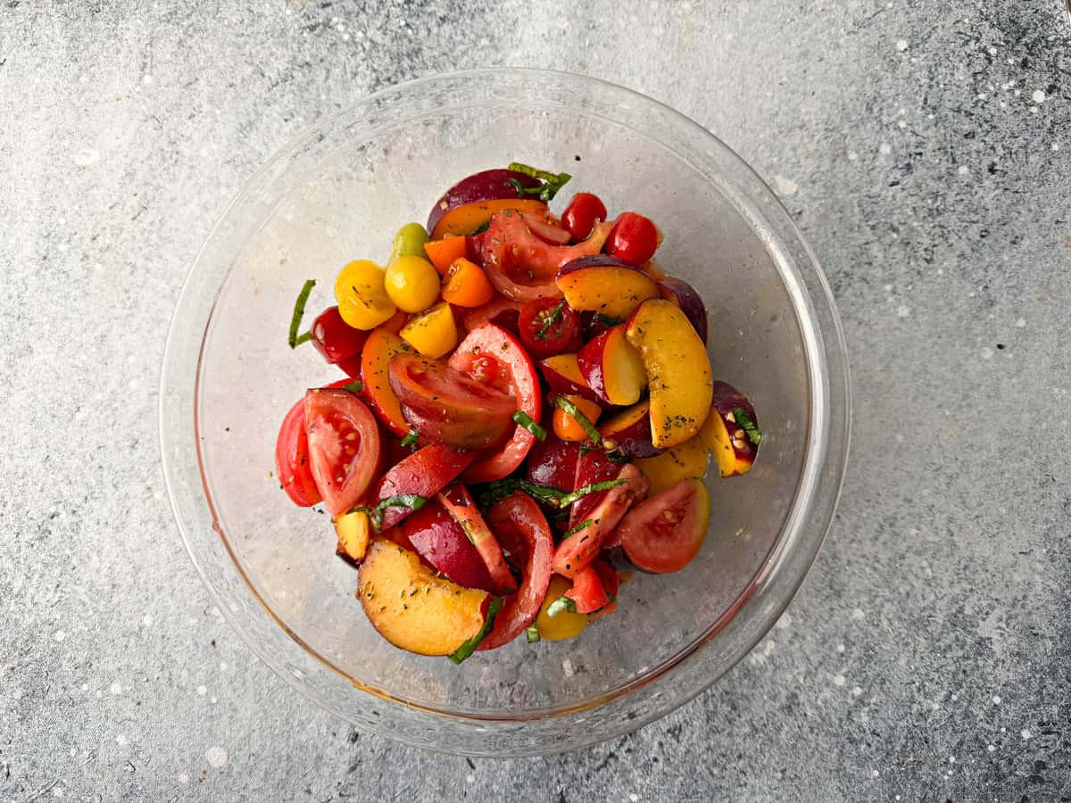 Balsamic vinaigrette added to our peach and tomato mixture and gently tossed.