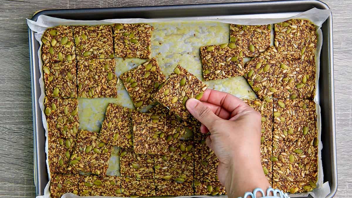 Baked seed crackers broken up into even squares and ready for serving.