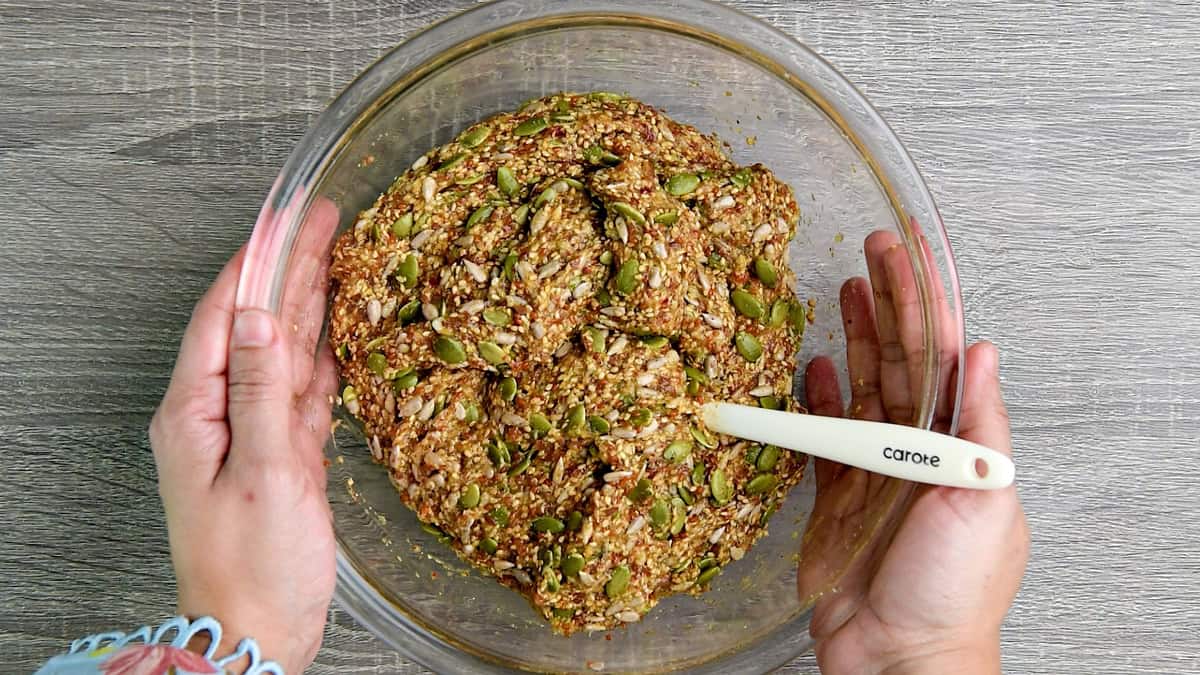 The seed mixture balled up into a dough like consistency inside the glass bowl.
