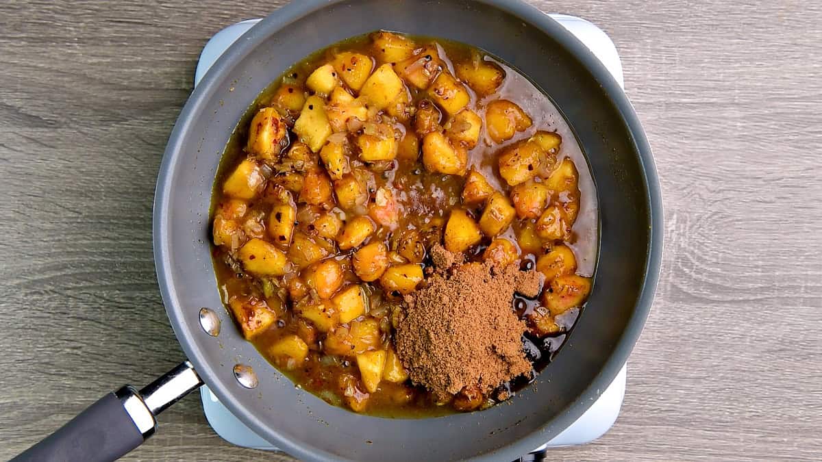 The peaches, spices, and onions all softened in the pan, and now I added apple cider vinegar and brown sugar for chutney.
